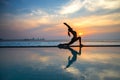 Silhouette young woman practicing yoga on swimming pool and the beach Royalty Free Stock Photo