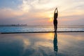 Silhouette young woman practicing yoga on swimming pool Royalty Free Stock Photo