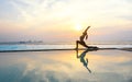 Silhouette young woman practicing yoga on swimming pool Royalty Free Stock Photo