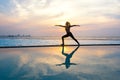 Silhouette young woman practicing yoga on swimming pool Royalty Free Stock Photo