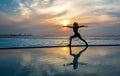 Silhouette young woman practicing yoga on swimming pool and the beach at sunset. Royalty Free Stock Photo