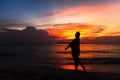 Silhouette of young woman relaxing on the beach at sunset Royalty Free Stock Photo