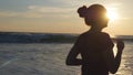 Silhouette of young woman running on sea beach at sunset. Girl jogging along ocean shore during sunrise. Female Royalty Free Stock Photo