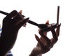 Silhouette of a young woman`s hands doing makeup in front of a pocket mirror, a girl dunks the brush in face powder on a white Royalty Free Stock Photo