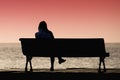 Silhouette of young woman sitting alone on the bench Royalty Free Stock Photo