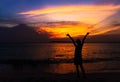 Silhouette of young woman spreading hand and relaxing on the beach Royalty Free Stock Photo