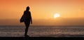 Silhouette of a young woman standing alone by the ocean Royalty Free Stock Photo