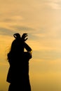 Silhouette of young woman standing at relax pose or freedom pose or chill pose Royalty Free Stock Photo