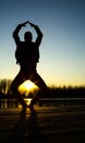 Silhouette of young woman at sunset doing yoga Royalty Free Stock Photo