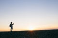 Silhouette of a young woman taking pictures on the camera at sunset Royalty Free Stock Photo