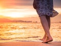 Silhouette of Young woman walking alone on the beach in the sunset Royalty Free Stock Photo