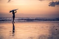 Silhouette of young woman walking along the beach at sunset Royalty Free Stock Photo