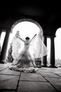 Silhouette of young woman wearing bridal gown in archway
