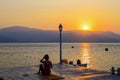 Silhouette of a young woman who performs yoga exercises on a summer morning on the seashore at sunrise. Sports, lifestyle.