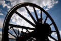 Silhouetted against the sky is an old wooden wagon buggy wheel. Royalty Free Stock Photo