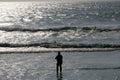 Silhouetted angler on beach