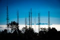 Silhouetted antennas on the top of a hill. Royalty Free Stock Photo