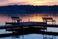 Silhouetted Benches on Wooden Pier at Sunset