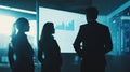 Silhouetted business professionals analyzing data on a large screen in a dark room. High-tech corporate environment and Royalty Free Stock Photo