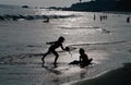 Silhouetted Children Playing on Beach