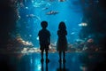Silhouetted children watching sharks in underwater aquarium Royalty Free Stock Photo