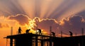 Silhouetted construction workers building against a fiery sunset sky white background white background Royalty Free Stock Photo