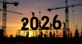 Silhouetted construction workers building the year 2026, structural framework against a vibrant sunset backdrop Royalty Free Stock Photo