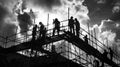 Silhouetted Construction Workers on Unfinished Building Against Cloudy Sky in Black and White Royalty Free Stock Photo