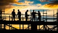 Silhouetted construction workers working atop scaffold at sunset Royalty Free Stock Photo