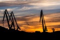 Silhouetted cranes at shipyard, Royalty Free Stock Photo