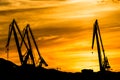 Silhouetted cranes at shipyard, Royalty Free Stock Photo