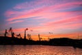 Silhouetted cranes at shipyard, Royalty Free Stock Photo