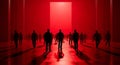 Silhouetted figures walking towards a bright red light in a minimalist corridor setting at night Royalty Free Stock Photo