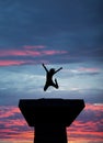 Silhouetted girl jumping on tower