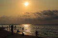 Silhouetted group of people on the beach and in the sea