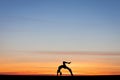 Silhouetted gymnast doing bow in sunset