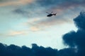 Silhouetted Helicopter Flying Across a Sunset Sky