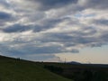 A Silhouetted image of a slope overgrown with a meadow of the Hoheward dump in the Ruhr area in Germany. Dramatic weather, a storm