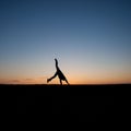 Silhouetted man doing a cartwheel at sunset Royalty Free Stock Photo