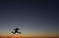 Silhouetted of man jumping in sunset Royalty Free Stock Photo