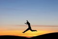 Silhouetted man jumping in sunset Royalty Free Stock Photo