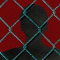 A silhouetted man is seen behind chainlink fence