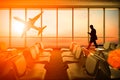 Silhouetted of man use mobile phone in airport at sunset. Business, connection and travel concept. Royalty Free Stock Photo