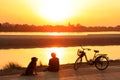 Silhouetted man watching sunset at Mekong river