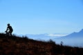 Silhouetted mountain biker pedalling uphill