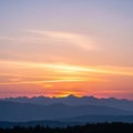 Silhouetted mountain range with sharp peaks beneath a colorful sunset sky. Layers of rolling hills Royalty Free Stock Photo