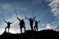 Silhouetted mountaineers on summit