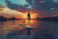 Silhouetted Paddleboarder on Serene Lake at Sunset Royalty Free Stock Photo