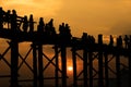 Silhouetted people crossing U bein bridge with sunset,The longest wooden bridge in Mandalay,Myanmar. Royalty Free Stock Photo