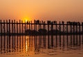 Silhouetted people on U Bein Bridge at sunset, Amarapura, Mandalay region, Myanmar. Burma. The longest and oldest teak Royalty Free Stock Photo